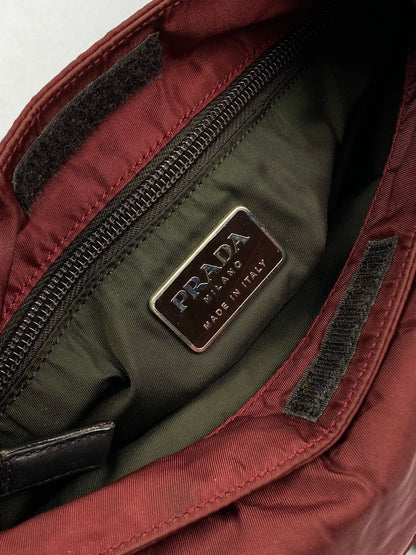 PRADA MILANO REVERSIBLE NYLON SLING BAG IN BURGUNDY.